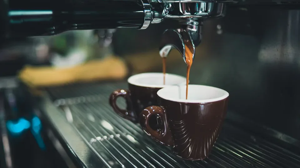 Cafeteira expresso preparando café para comparar com cafeteira de cápsula